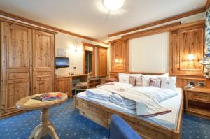 摩德纳迪-坎皮格里奥吉安娜酒店的一间卧室配有一张大床和一张桌子