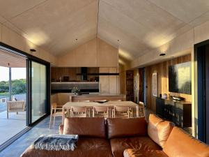 布雷默贝Native Dog Cabin的客厅配有棕色沙发和桌子