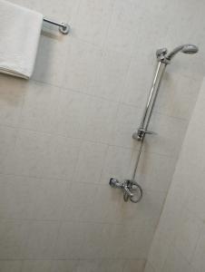 苏尔Al Basateen Hotel Apartment的浴室设有白色瓷砖墙和淋浴。