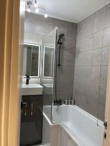 伦敦Self-catering fully equipped apartment in Vauxhall的带淋浴、浴缸和盥洗盆的浴室