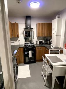 伦敦Self-catering fully equipped apartment in Vauxhall的厨房配有炉灶和桌子。