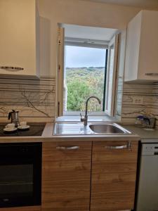 茨雷斯Lavanda apartman 1的厨房设有水槽和窗户。