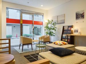 东京Tabist Ginza的一间设有两张床和一张桌子及椅子的房间