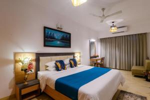 桑戈尔达Lotus & Orchid Villas by Ramnath Homes的一间卧室配有一张大床,提供蓝白色的毯子