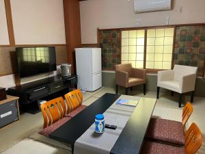 京都京都祗园佐野旅馆的客厅配有桌椅和电视。