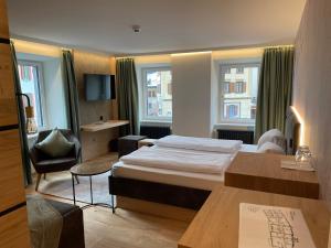 策尔内茨Hotel Spöl Restaurant的配有一张床和一张书桌的酒店客房