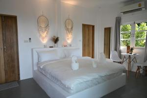 哈德姚Bao Village的白色卧室配有一张带两个蜡烛的大型白色床