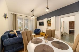 布拉索夫Luxury Landing Apartments Complex Qualis Brasov的客厅配有桌子和蓝色沙发