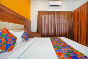 班加罗尔FabHotel Greenwood Xpress的一间卧室配有一张带彩色毯子的床