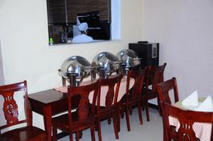亚的斯亚贝巴Guzara Hotel Addis的一间带桌椅的用餐室和一间厨房