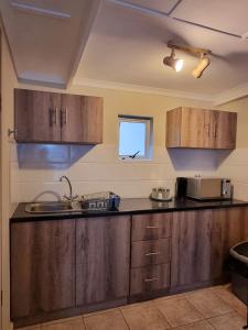 东伦敦Private Guest Suite with 24hr Electricity, East London的一个带木制橱柜和水槽的厨房