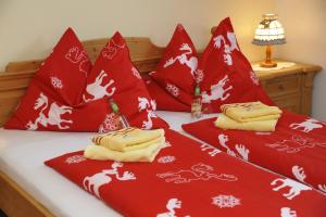 毛特恩多夫Landhaus Gartler的一张带红白毯子和枕头的床