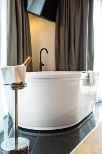 布雷西亚马斯特酒店的带淋浴的浴室配有白色浴缸。