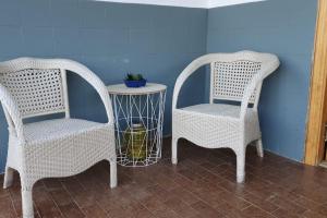 格拉纳达Casa rural en Padul entre Sierra Nevada y la Costa的两个柳条椅和一张桌子