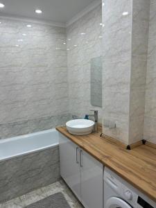 奇姆肯特Двухкомнатная квартира的浴室配有盥洗盆和浴缸。