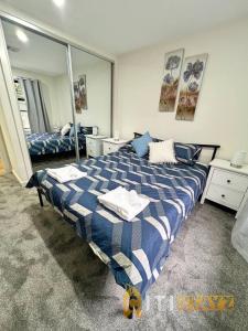 LyonsLavish in Lyons - 3bd 2bth Spacious & Modern Home的卧室配有蓝色和白色的床和镜子