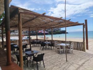 莫罗尼Maison de charme dans la capitale的海滩上的餐厅,配有桌椅