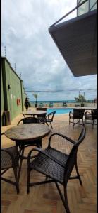 纳塔尔Natal Plaza 604-Ponta Negra的一个带桌椅的庭院和一个游泳池