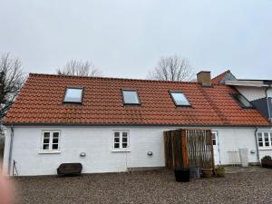 SvebølleFarmens Gæstehus的白色房子,有红色屋顶
