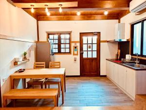 台南末廣通二館 日式包棟民宿Suehirodori Japanese Entire Homes No2的厨房配有木桌、椅子和桌子