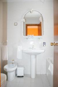 别尔萨Hostal Los Valles的白色的浴室设有水槽和卫生间。