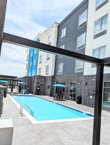 JenksCandlewood Suites - Tulsa Hills - Jenks, an IHG Hotel的大楼前的游泳池