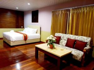 苏梅岛Raya Ville的一间卧室配有一张床、一张沙发和一张桌子
