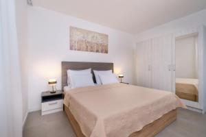 木洛希尼House Torre Apartments的白色卧室配有一张大床和两盏灯。