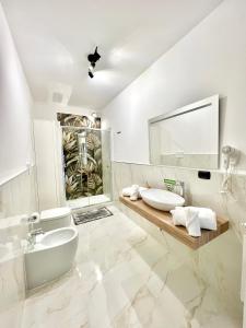 菲乌米奇诺Hangar Inn的白色的浴室设有两个盥洗盆和镜子