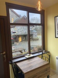 金尤西Uist Cottage的桌子和享有谷仓景致的窗户