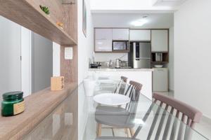 帕纳米林Qavi - Flat em Resort Beira Mar Cotovelo #InMare109的厨房以及带桌椅的用餐室。