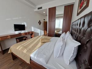 波德戈里察Motel Celebic的一间卧室配有一张带皮革床头板的大床