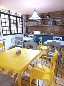 马塞约HOSTEL Recanto do Cajueiro的用餐室配有黄色的桌椅