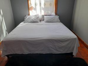 开普敦IKHAYA2 long street的一张带白色床单和枕头的床