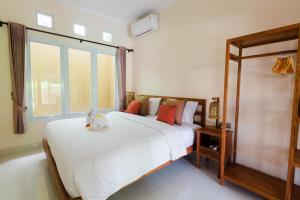 金巴兰Donguri House Bali的一间卧室设有一张大床和一个大窗户