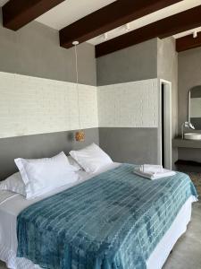 塞尔苏拉穆斯州长镇Villa dos Ganchos的一间卧室配有一张带蓝色毯子的大床
