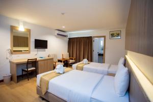 梭桃邑Sea Paradise Hotel Sattahip的酒店客房配有两张床和一张书桌