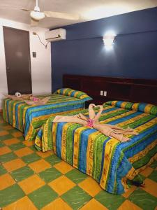 韦拉克鲁斯Hotel Verasol的两人卧床,房间有人躺在床上