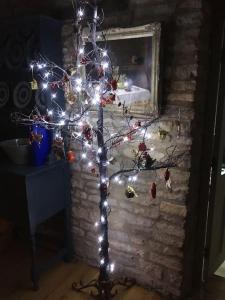 奇平诺顿3 BEDROOM 5* BARN CONVERSION COTSWOLDS的壁炉前的圣诞树和灯