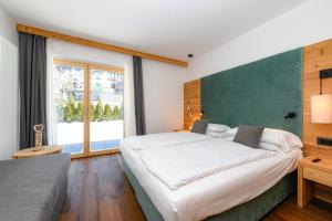 GiustinoBepy Hotel Garni的一间卧室设有一张大床和一个大窗户