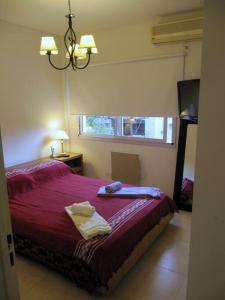 布宜诺斯艾利斯Nuevo y bonito departamento en Saavedra-CABA的一间卧室配有红色的床和毛巾