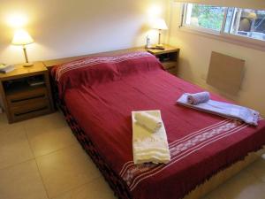 布宜诺斯艾利斯Nuevo y bonito departamento en Saavedra-CABA的一间卧室配有红色的床和2条毛巾