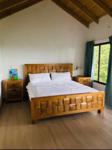 Los CorozosLote 13N (Quintas del Bosque) Los Helechos的一间卧室配有一张大木床和白色床单