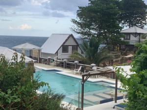 安东尼奥港The Sea Cliff Hotel Resort & Spa的一座房子和大海旁的游泳池
