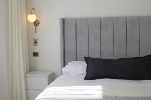 塔尔卡Hotel Marcos Gamero的卧室配有白色床和灰色床头板