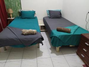 普拉亚In The Heart Of Praia - Family B&B的配有两张床铺的蓝色床单和枕头