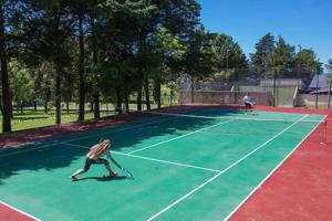 美国别墅城Condominio Monte Molinos - dpto en Nautico, 2 dormitorios y vista al lago的两人在网球场打网球