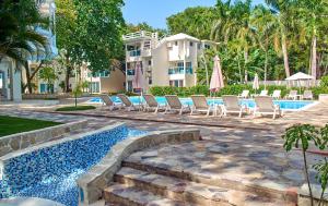喀巴里特Tropical Casa Laguna的一座带游泳池和椅子的度假村和一座建筑