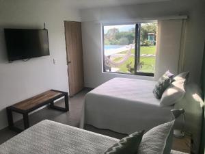 金巴亚Torcaza Casa de Campo的酒店客房设有两张床和电视。
