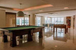帕纳米林Qavi - Flat em Resort Beira Mar Cotovelo #InMare109的一间设有台球桌和两张桌子的房间